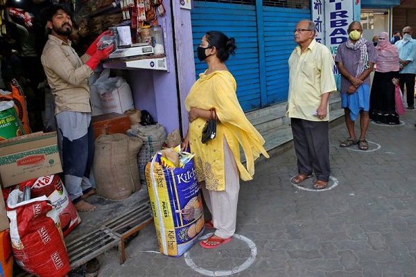 People queue standing in circles drawn to maintain safe distance as they wait to buy grocery items during a 21-day nationwide lockdown to limit the spreading of Coronavirus disease (COVID-19), in Kolkata